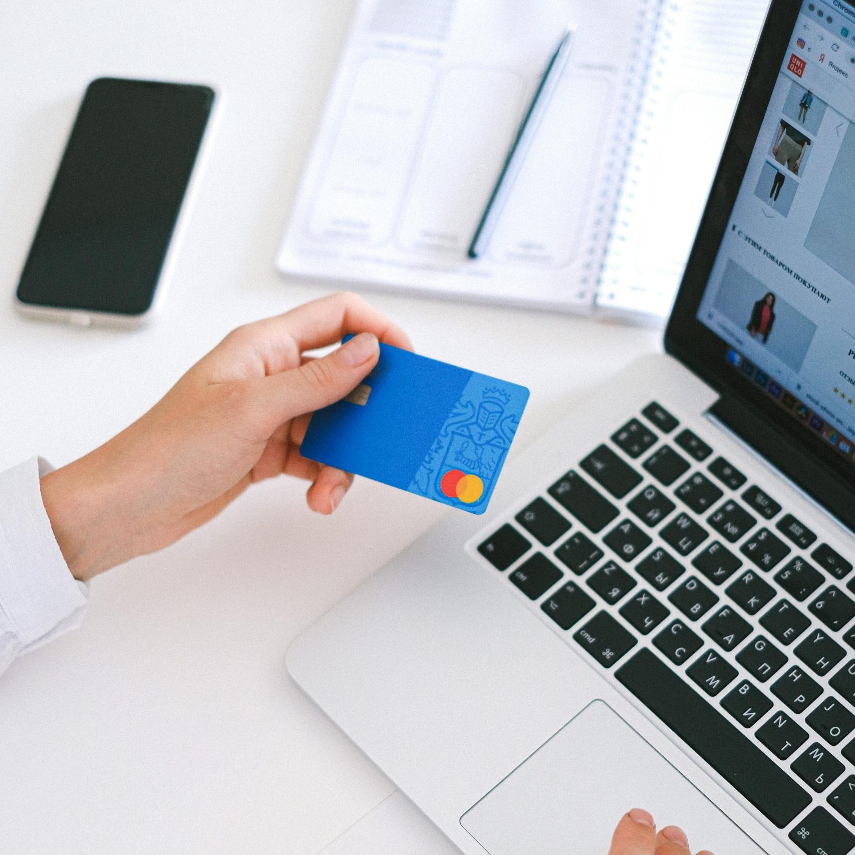 Person making an online purchase with a credit card on a laptop, showcasing modern ecommerce technology.